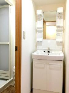 a bathroom with a white sink and a mirror at Isshuku Ryokan Asakusabashi - Vacation STAY 17346v in Tokyo