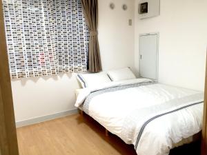 a bedroom with a bed and a window at Isshuku Ryokan Asakusabashi - Vacation STAY 17346v in Tokyo
