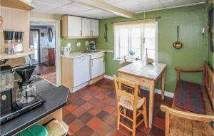 a kitchen with green walls and a table and chairs at Awesome Home In Samsø With Kitchen in Onsbjerg
