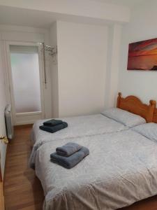 格哈爾謝拉的住宿－Apartamento Guejar Sierra，卧室内的两张床,配有两条毛巾