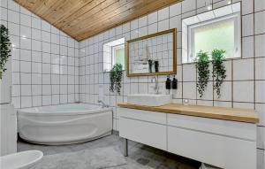 a bathroom with a tub and a sink and a toilet at Nice Home In Ebeltoft With 4 Bedrooms in Ebeltoft +23 photos