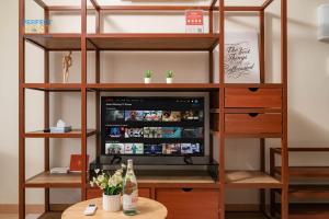 a television in a book shelf with a table at Timurbay Beachfront by Perfect Host in Kuantan