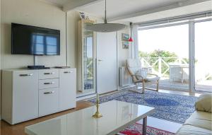a living room with a tv and a couch at Amazing Apartment In Gudhjem With 2 Bedrooms & Wifi in Gudhjem