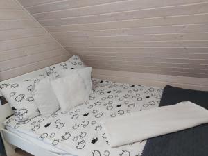 łóżko z czarno-białą pościelą i poduszkami w obiekcie Sunny Baltic w mieście Jarosławiec