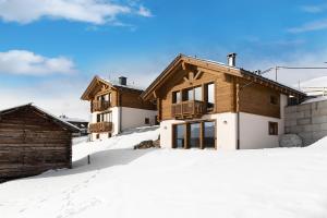 una casa de madera en la nieve en Plaz, en Livigno