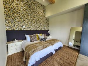 a bedroom with a large bed and a large mirror at Little Prestwick on Gowrie Farm, Nottingham Road in Nottingham Road