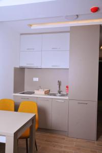 a kitchen with white cabinets and a sink and a table at Apartman A20B in Kopaonik