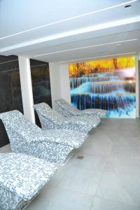 a group of chairs in a room with a waterfall mural at Apartman A20B in Kopaonik