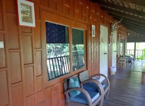 a room with wood paneling and windows on a house at Bulunburi Resort in Ban Pong