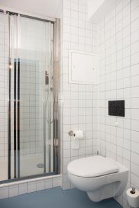 La salle de bains blanche est pourvue d'une douche et de toilettes. dans l'établissement Pilo Lyon, à Lyon