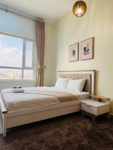 a bedroom with a large bed with a window at Abu Rakan Apartment in Muscat