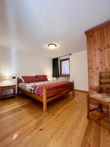 Schlafzimmer mit einem Bett und Holzboden in der Unterkunft Maison Arcade in Challancin