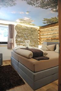 Un dormitorio con una pared de piedra y una cama en Apart Oetz, en Oetz