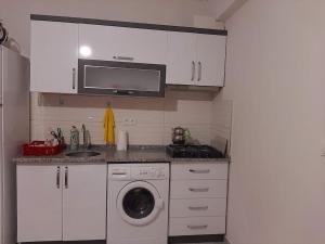 New renovated 1+1 flat in Kültür في أنطاليا: مطبخ بدولاب بيضاء وغسالة ملابس