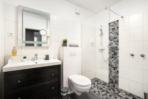 uma casa de banho com um WC, um lavatório e um chuveiro em Hotel garni Marktterrassen em Hennef