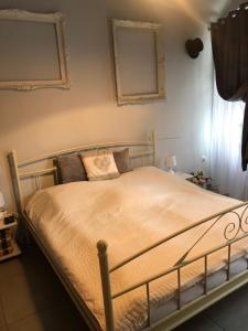 a bedroom with a bed with a metal frame at Godot Apartman in Miskolc