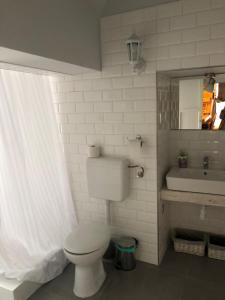 a bathroom with a white toilet and a sink at Godot Apartman in Miskolc
