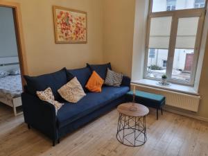 a living room with a blue couch and a table at Igo apartment Uzupis in Vilnius