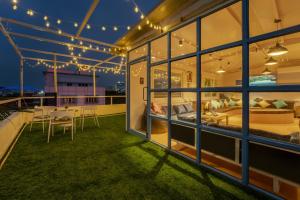 a house with a balcony with a bed and a table at Zostel Hyderabad in Hyderabad