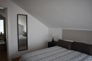 a white bedroom with a bed and a mirror at Placeta Boutique in Rute