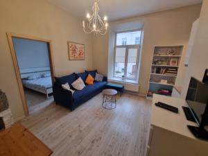 a living room with a blue couch and a table at Igo apartment Uzupis in Vilnius