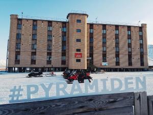 Un gran edificio con un cartel delante. en Hotel Pyramiden, en Pyramiden