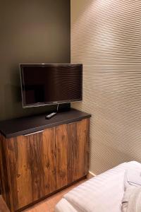een flatscreen-tv op een houten standaard in een slaapkamer bij Montes Szymoszkowa in Kościelisko