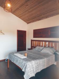 - une chambre avec un grand lit et un plafond en bois dans l'établissement Bangalô pontal beach house, à Fortim