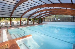 una grande piscina con soffitto aperto di Camping La Pinède a Excénevex