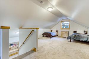 a attic bedroom with two beds and a staircase at Oak Street Retreat in Sisters