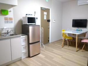 Il comprend une cuisine équipée d'un réfrigérateur et d'une table avec des chaises. dans l'établissement Hitoyado Ryokan Higashiueno - Vacation STAY 72556v, à Tokyo