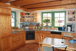 una cocina con armarios de madera y una mesa. en Ferienhaus Schellerhäusl en Kurort Altenberg