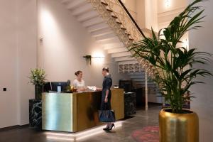 two people standing at a counter in an office at Hotel Kaiserhof Ravensburg in Ravensburg