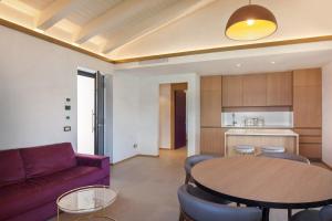 un soggiorno con un divano viola e un tavolo di Villa Divina22- APT Icona con piscina e vista lago a Castelletto di Brenzone