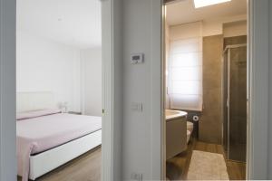Habitación pequeña con cama y baño. en Casa Armonia by MONHOLIDAY, en Monopoli