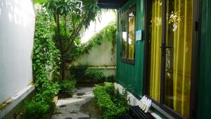 Cửa Biển Homestay في هاي فونج: منزل أخضر وأصفر مع فناء بالنباتات