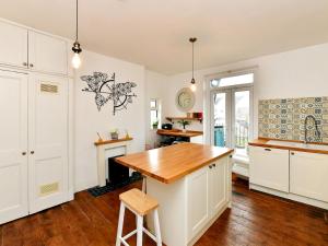 une cuisine avec des placards blancs et un comptoir en bois dans l'établissement Pass the Keys Spacious 3 Bedroom Apartment Close to City Centre, à Cardiff