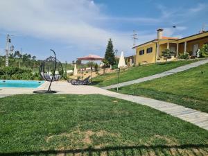 um quintal com uma casa e uma piscina com uma escultura em Quinta da Laceira - Douro Valley - Alojamento Local em Vila Real