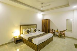 a bedroom with a large bed and a table at FabHotel White House BNB in New Delhi