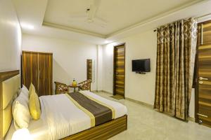 una camera d'albergo con letto e TV di FabHotel White House BNB a Nuova Delhi