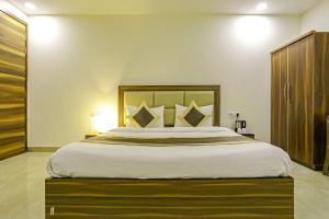 a bedroom with a large bed with a wooden headboard at FabHotel White House BNB in New Delhi
