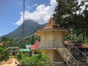 Palabaddala Tea and Eco Lodge في راتنابورا: مبنى صغير فيه درج امام جبل