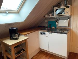 a small kitchen with a stove and a microwave at Korsanäs in Listerby