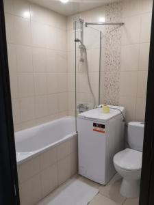 een badkamer met een toilet, een bad en een wastafel bij Квартира в центрі Світлі мрії Avenue Myru35 in Chernihiv
