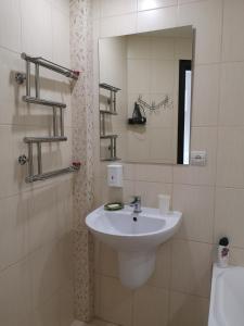 een badkamer met een wastafel en een spiegel bij Квартира в центрі Світлі мрії Avenue Myru35 in Chernihiv