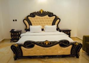 - un grand lit avec une grande tête de lit dans une chambre dans l'établissement Kawruky Hotel Benin, à Benin City