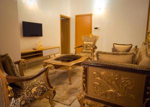- un salon avec des chaises, une table et une télévision dans l'établissement Kawruky Hotel Benin, à Benin City