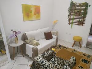 uma sala de estar com um sofá e uma mesa em Confortável apartamento no centro ano bom em Barra Mansa