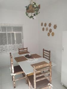 a dining room table with two chairs and a white wall at Confortável apartamento no centro ano bom in Barra Mansa