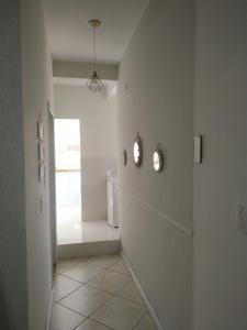 um quarto com um corredor com paredes brancas e uma janela em Confortável apartamento no centro ano bom em Barra Mansa